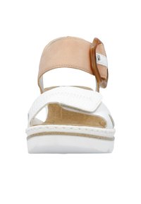 Sandalo in pelle bianca con cinturino alla caviglia color marrone chiaro e grande fibbia marrone. Suola piatta e dettagli cuciti sulle cinghie. Design open-toe.