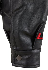 Manche en cuir noir à finition texturée, ornée d'un accent brodé rouge et noir et d'un bouton-pression en métal argenté au niveau du poignet.