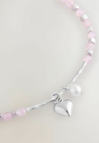 Pink beaded necklace with silver accents. Features a shiny heart charm and a pearl detail. Strands twisted, smooth texture.