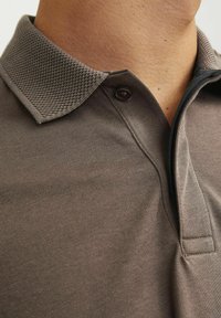 Hnedé polo tričko s textúrovaným golierom, gombíkom pri krku a hladkým materiálom s jemným vzorom.