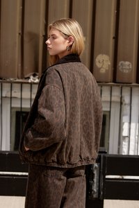 Oversized jakke i leopardmønster i mørkebrun med ribbestrikket krage og elastiske mansjetter. Har en avslappet passform og en uformell denimtekstur.