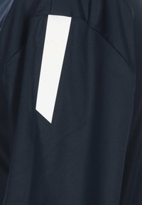 T-shirt de sport marine avec une bande blanche en biais sur l'épaule. Fabriqué en tissu lisse et respirant avec une coupe décontractée.