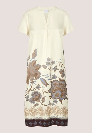 Crèmekleurige jurk tot op de knie met korte mouwen, een V-hals en blauwe en bruine bloemmotieven langs de onderkant en zoomrand.
