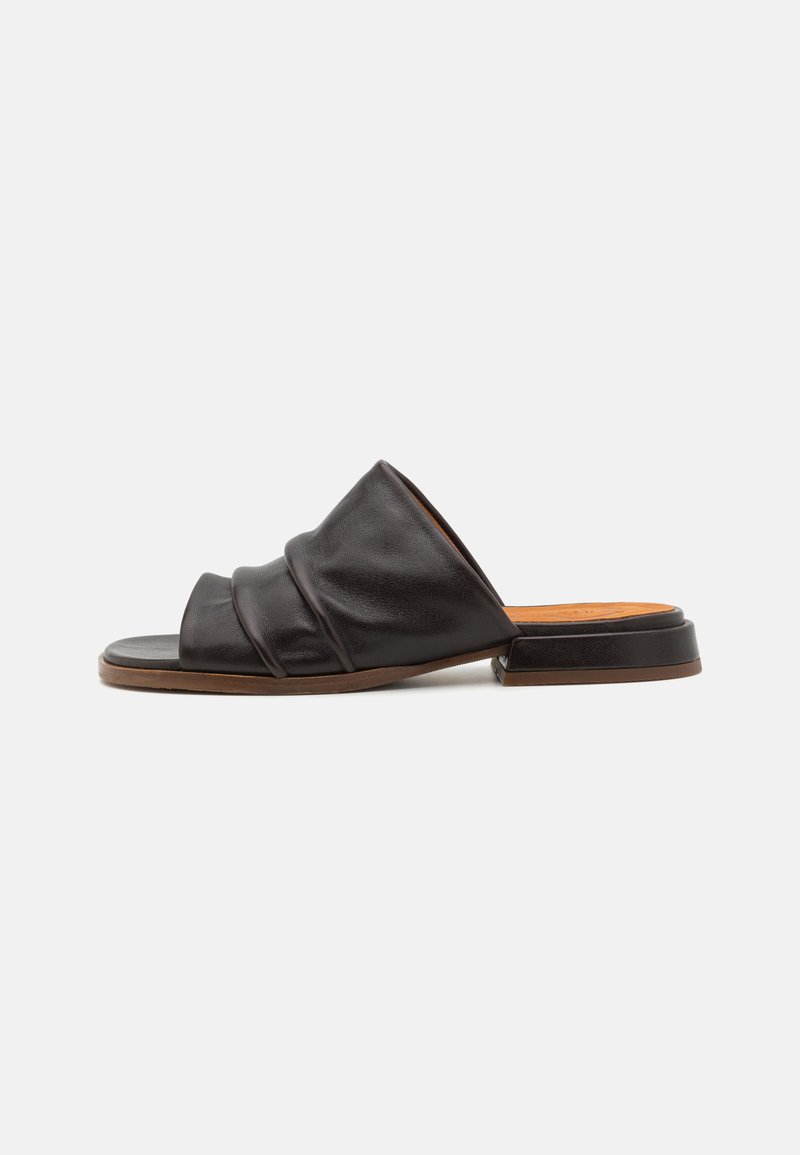 Sandal in pelle nera con tre pieghe morbide sulla parte superiore, punta aperta e tacco basso a blocco. Superficie liscia e soletta beige chiaro.