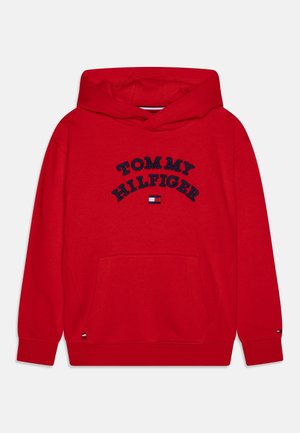Červená bavlněná mikina s kapucí s velkým vyšitým logem "TOMMY HILFIGER" v námořnické modři, přední kapsou a pružnými manžetami s akcenty loga.