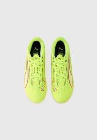 Scarpe da calcio giallo neon con tomaia testurizzata, presentano accenti rossi, interno nero e un logo contornato di bianco sul lato.