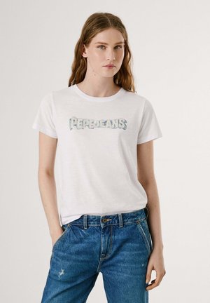 T-shirt bianca in cotone con una grafica azzurro chiaro "Pepe Jeans" sulla parte anteriore. Abbinata con jeans in denim blu, caratterizzati da una vestibilità rilassata e una texture sbiadita.