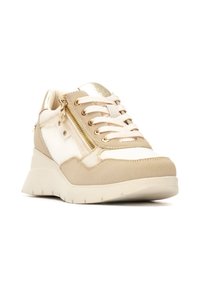 Zapatilla atlética beige con un tacón en cuña, que presenta una tela texturizada y detalles en dorado brillante, cierre de cordones y un detalle de cremallera lateral.