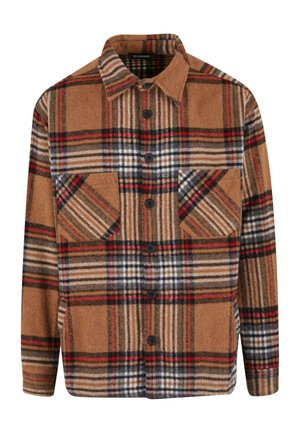 Camisa de franela a cuadros marrón que presenta acentos en rojo, negro y blanco, con botones en la parte delantera y dos bolsillos en el pecho con solapas en ángulo.