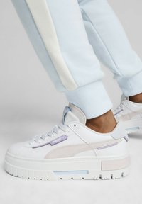 Sneaker platform bianche con accenti lilla e beige, materiali in suede testurizzato e pelle liscia, e un design con suola chunky.