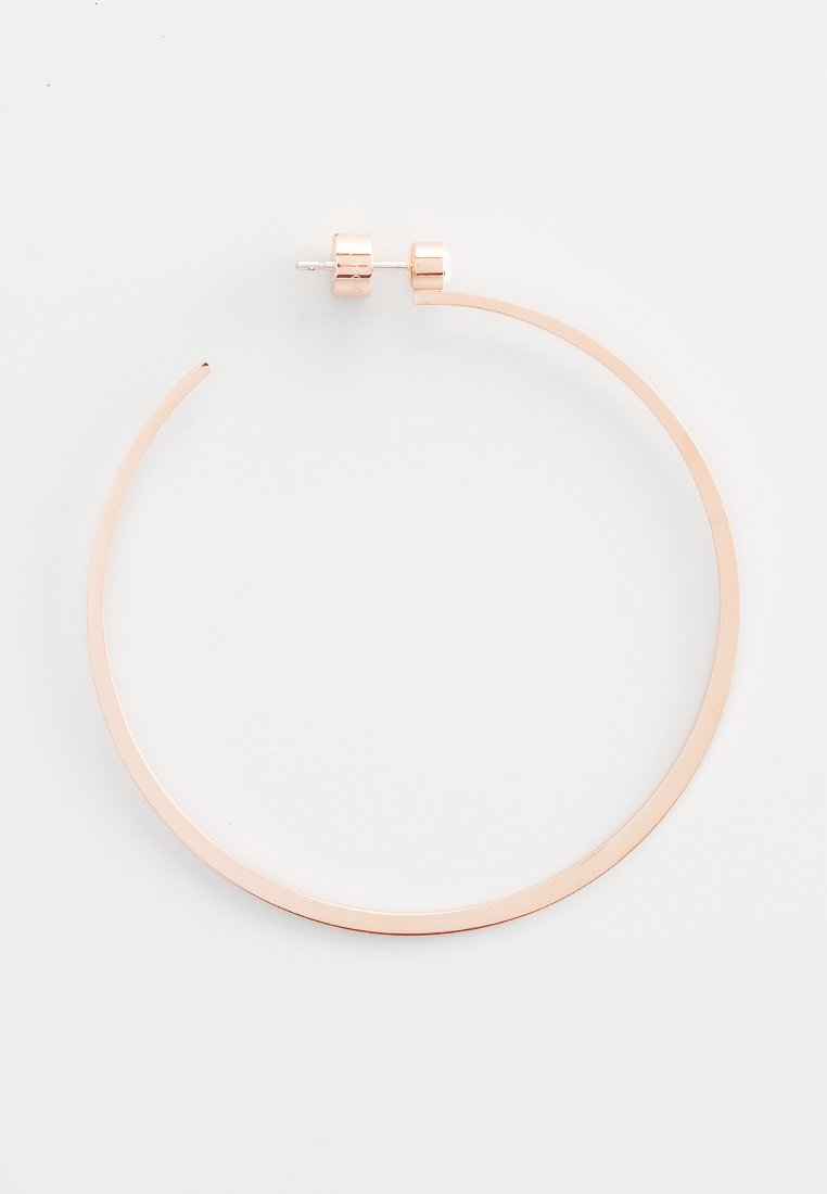 Boucle d'oreille en or rose, mettant en avant un design circulaire fin avec une finition polie et une fermeture par tige sécurisée.