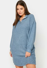 Abito in pile blu con collo a mezzo zip e maniche lunghe, caratterizzato da una vestibilità comoda e una texture morbida. Nessun motivo o accento prominente.