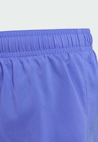 Pantaloni corti con elastico in vita realizzati in tessuto leggero e liscio di un vivace blu chiaro; presentano una texture arricciata lungo l'elastico.
