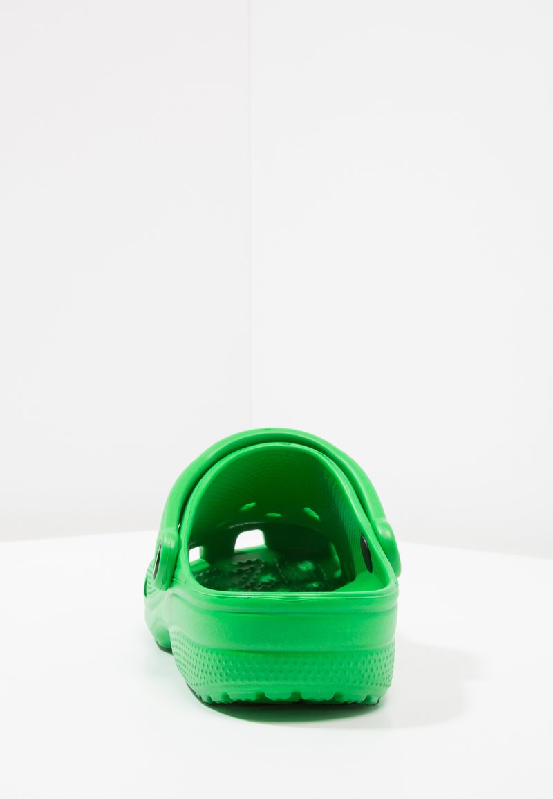 Zielone klapki wykonane z formowanego plastiku, z tylnym paskiem, otworami wentylacyjnymi, teksturowaną wkładką oraz gładkim wykończeniem.