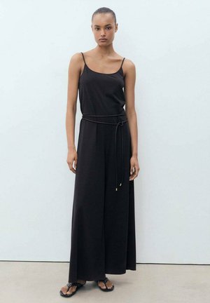 Mono negro sin mangas con un ajuste relajado, un cinturón a la cintura y patas anchas. Textura de tela suave; diseño minimalista sin patrones.
