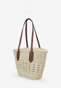 Bolso de mano de paja trenzada con asas de cuero marrón. Presenta un diseño texturizado y apertura superior, adecuado para el uso diario.