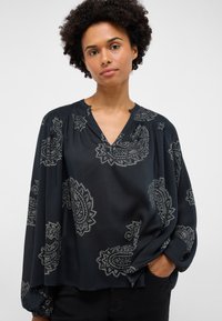 Czarna bluzka z motywem paisley, lekka tkanina, dekolt w szpic, długie, luźne rękawy, marszczenia na ramionach, luźny krój.