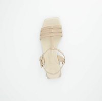 Sandal a blocco nudo con tacco largo e tre cinturini stretti sul davanti, dotata di una cinghia alla caviglia regolabile. Realizzata in materiale sintetico liscio e con punta quadrata.
