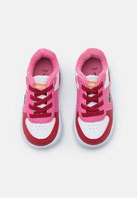 Růžové a červené tenisky s bílou síťovanou svrchní částí, zdobené růžovými tkaničkami, měkkým límcem a výšivkou zeleného kaktusu. Kulatá špička s perforacemi.