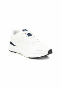Zapato deportivo blanco con material de malla, punta redonda y tejido texturizado. Presenta lengüeta y acentos en azul marino, suela de goma negra.