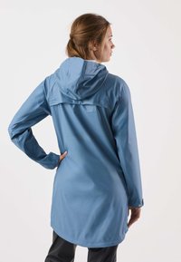 Vattentät blå jacka med huva, långa ärmar och en avslappnad passform. Har en slät textur och en något böjd fåll.