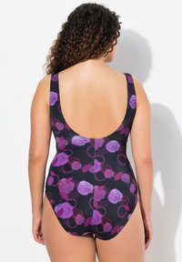 Maillot de bain une pièce noir avec un dos plongeant, orné de motifs floraux violets et roses. Fait en tissu texturé et extensible pour plus de confort.