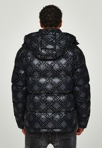 Padded black puffer jacket with a shiny finish, featuring an embossed geometric pattern, a hood, and ribbed cuffs.