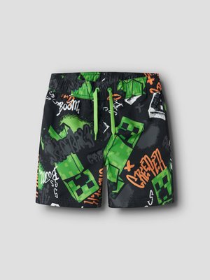 Schwarze Shorts mit grünen, pixeligen Creeper-Figuren und Graffiti-artigem Text in Grün, Orange und Weiß, mit grünem Kordelzug in der Taille.