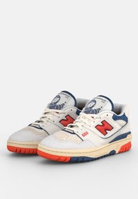 Baskets en mesh blanc et daim avec des accents bleus et rouges, ainsi qu'une languette à motif ; dotées d'une semelle amortie et du logo "N" bien visible.