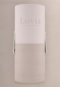 Zachtroze, cilindervormige cosmetische borstelhuls met een reliëftekst "Luvia Cosmetics" en een subtiel patroonontwerp op de onderste helft.