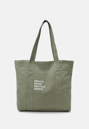 Sac fourre-tout réutilisable vert avec de longues anses et une poche avant affichant « RÉDUIRE RÉUTILISER RECYCLER RÉPÉTER » en texte blanc.