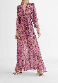 Rosa genomskinlig klänning med leopard- och zebramönster, med långa ärmar, V-ringning, ett knut vid midjan och en flödig nederdel.