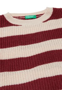 Pletený svetr s širokými vodorovnými pruhy v burgundské a béžové barvě a zelenou etiketou United Colors of Benetton na výstřihu.