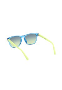 Una pareja de gafas de sol con un marco azul translúcido, lentes en degradado verde y varillas amarillas brillantes. Presenta un diseño angular, inspirado en la retro.