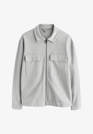 Light gray long-sleeve jacket with a collar, front zipper, and two large flap pockets on the chest.