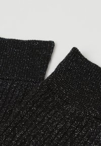 Sorte ribbede sokker med en skinnende metallisk tråd, der skaber en tekstureret overflade med en blød og fleksibel pasform.