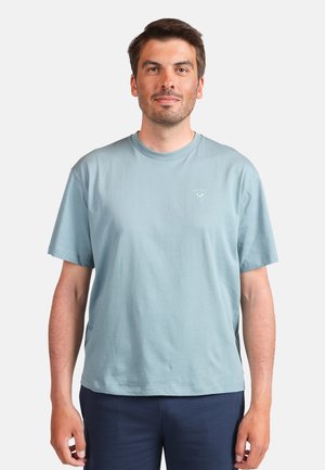 T-shirt in cotone azzurro chiaro con collo rotondo e maniche corte. Presenta un piccolo logo sulla parte superiore sinistra del petto. Tessuto piatto, vestibilità rilassata.