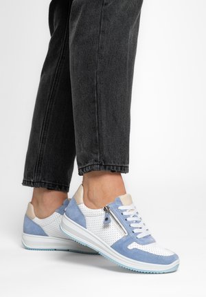 Low-top white sneakers with light blue suede accents and side zipper worn with black cropped jeans on a white background.