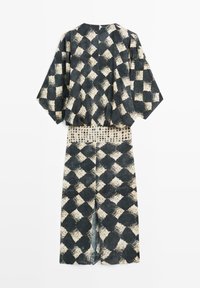 Schwarz-weiß kariertes, locker sitzendes Kimono-Oberteil mit weiten Ärmeln, kombiniert mit einem passenden langen Rock mit Schlitz vorne.