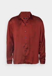 Camicia rossa in satin a maniche lunghe con colletto, chiusura frontale con bottoni e texture liscia. Presenta maniche allungate e una vestibilità comoda.