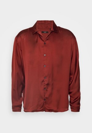 Camisa roja de satén de manga larga con cuello, cierre de botones delanteros y una textura suave. Presenta mangas alargadas y un ajuste relajado.