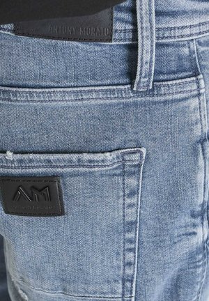 Jeans in denim azzurro chiaro con passanti per cintura visibili e toppe in pelle nera con il logo "Antony Morato" impresso sulla cintura e sulla tasca.