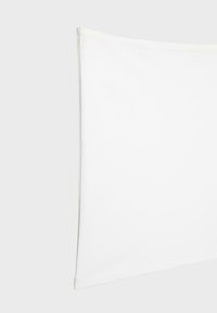 Coussin rectangulaire blanc avec une surface lisse et des coutures discrètes le long des bords sur un fond gris clair.