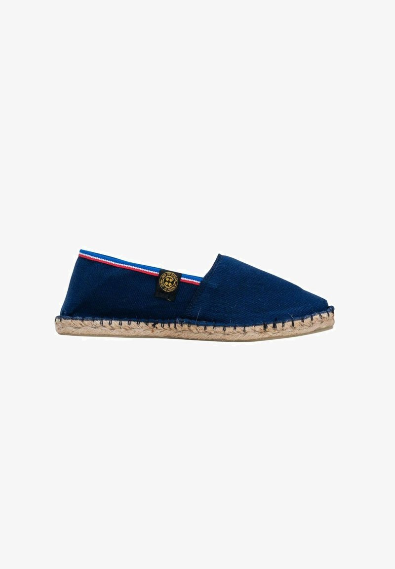 Espadrille en toile marine avec une semelle en jute tressé, arborant un petit badge logo et des rayures rouges et blanches le long du bord d'ouverture.