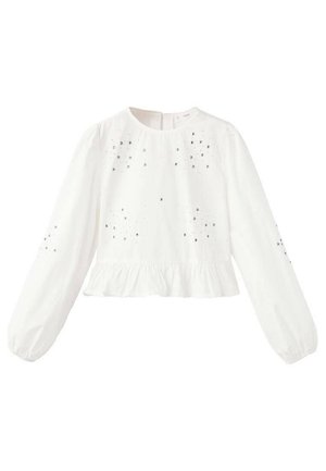Haut blanc à manches longues avec un col rond, un ourlet à volants et des embellissements argentés décoratifs dispersés sur le devant et les manches.