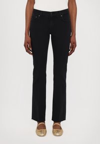 Svarta denimjeans med rak ben, fransad fåll, femfickorsdesign och metallknäppning. Kombination med vävda metalliska lägenheter.