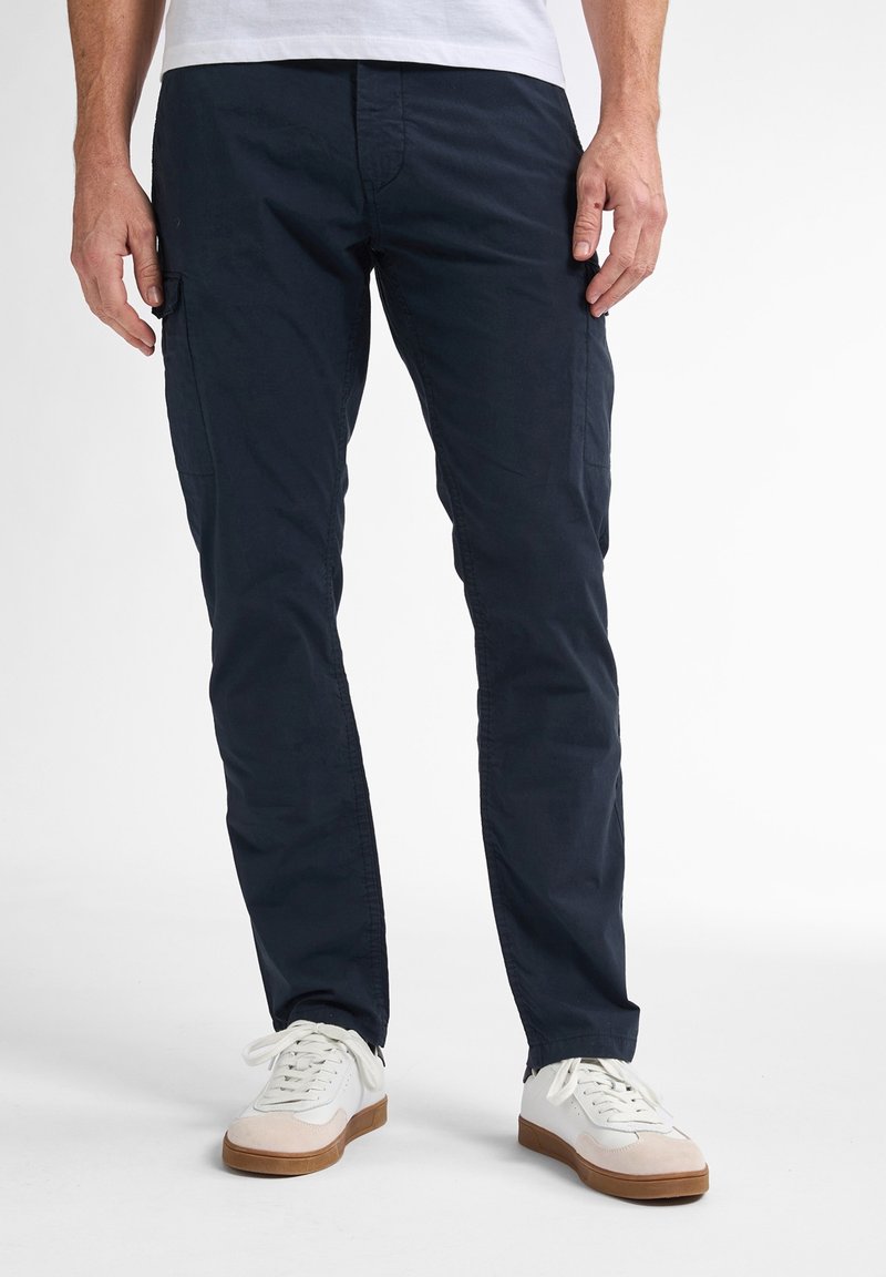 Marine cargo bukser med slim fit, der har sidelommer og en glat bomuldsstruktur. Sammen med hvide sneakers og en simpel hvid skjorte.
