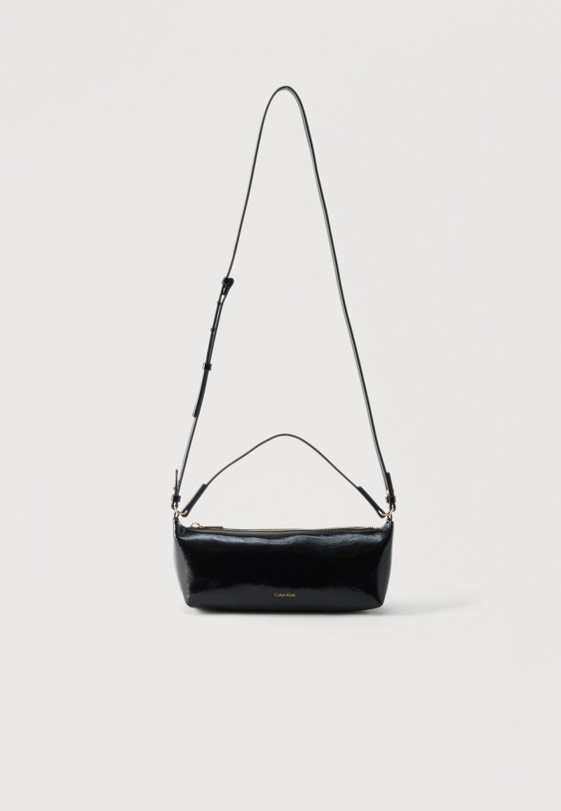 Μαύρη ορθογώνια δερμάτινη τσάντα χιαστί με ρυθμιζόμενο λουράκι ώμου, επάνω φερμουάρ και μικρό χρυσό λογότυπο Calvin Klein στο μπροστινό μέρος.