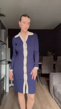 Abito lavorato a maglia blu navy con collo e bottoni bianchi a contrasto. Presenta una silhouette aderente e un design di lunghezza media con uno spacco laterale.