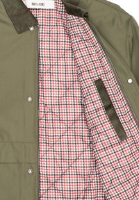 Chaqueta verde oliva con cuello de sarga, que presenta un forro con un patrón de pata de gallo en rojo, negro y blanco, y un cierre de cremallera.